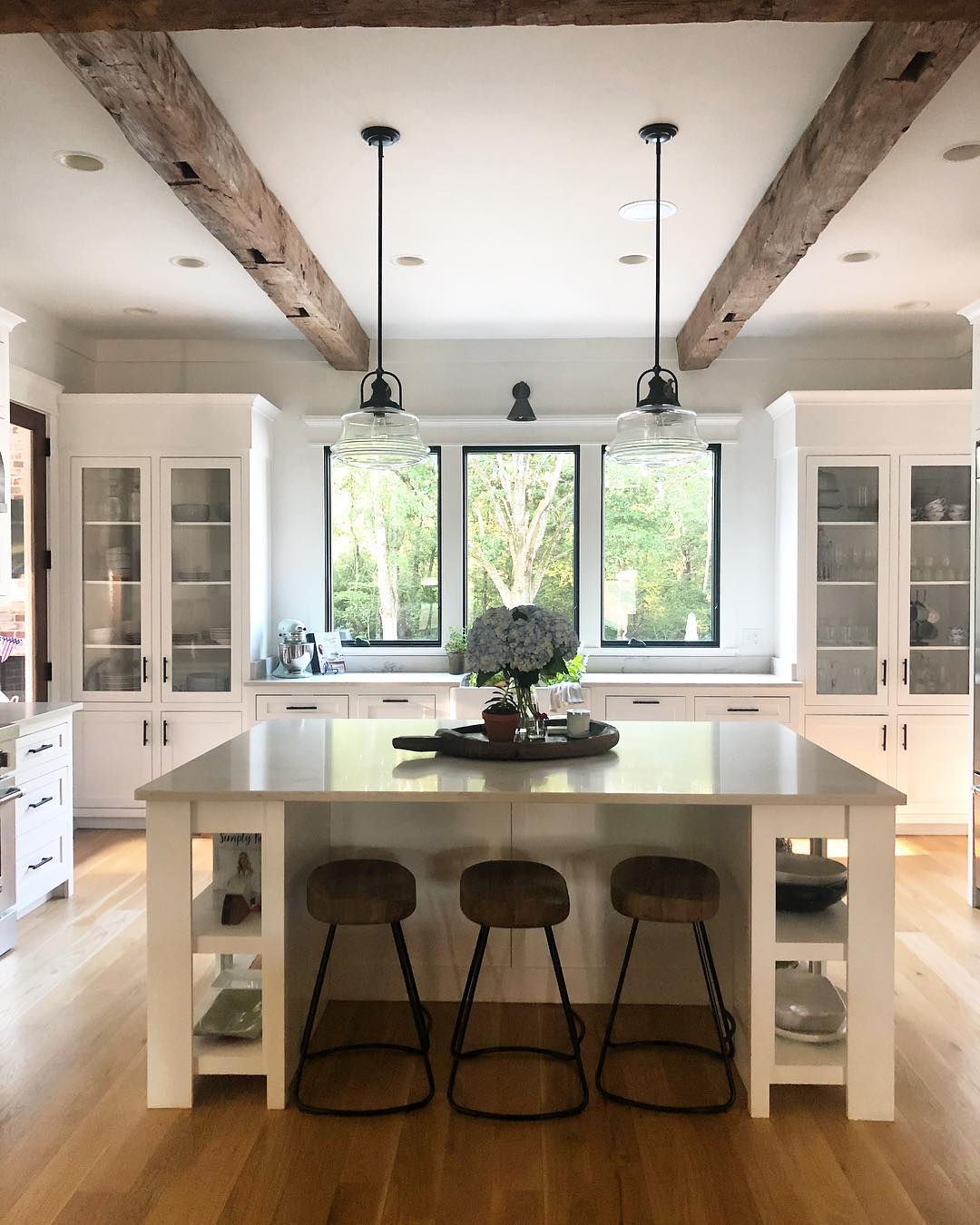 Modern kitchen with giant island. Photo by Instagram user @betweenyouandmedesigns