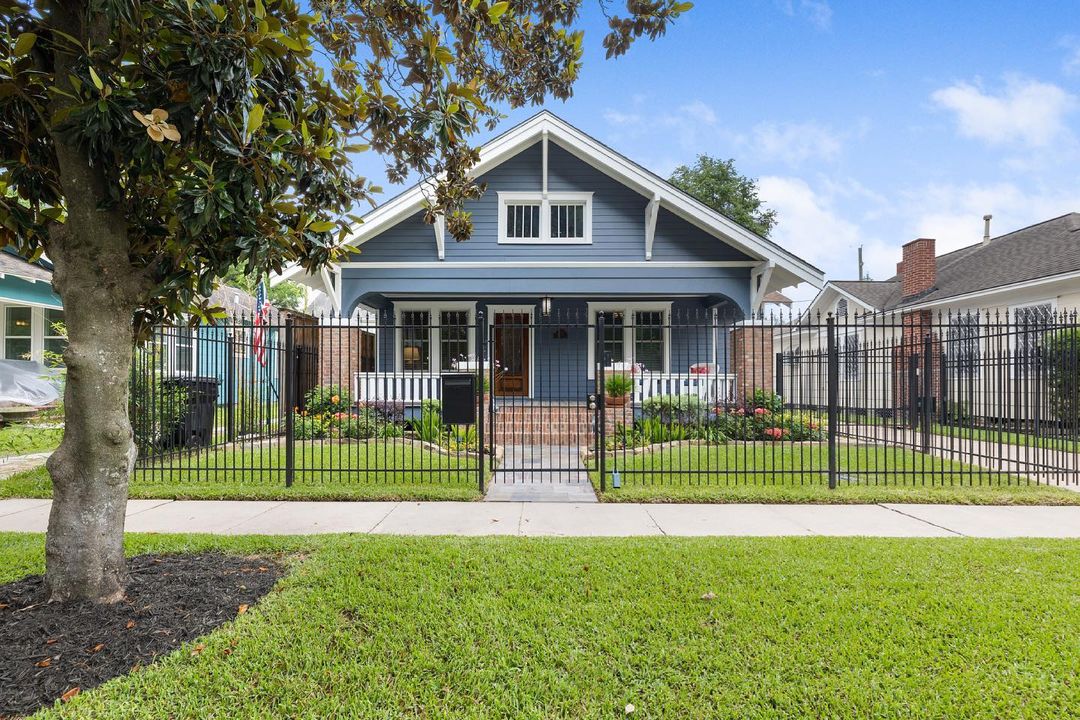 Blue bungalow style home with fenced in front yard. Photo by Instagram user @krantzlinngroup