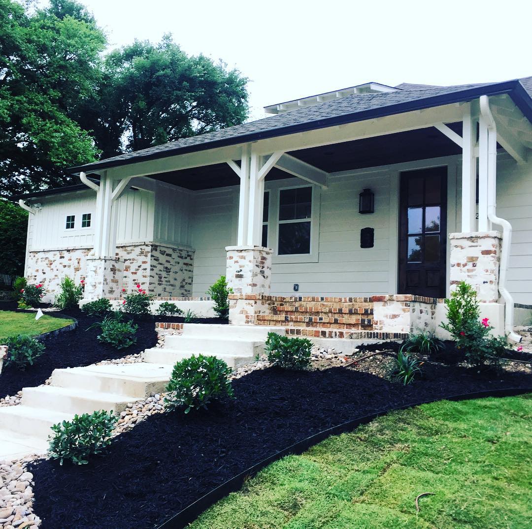Front of single-family home painted white with brick trim. Photo by Instagram user @joyeuxhd