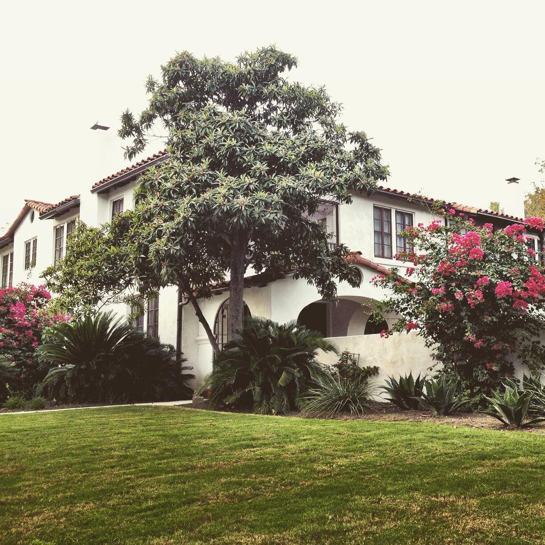 Side view of large multi-level home with white stucco and intricate landscaping. Photo by Instagram user @safabu