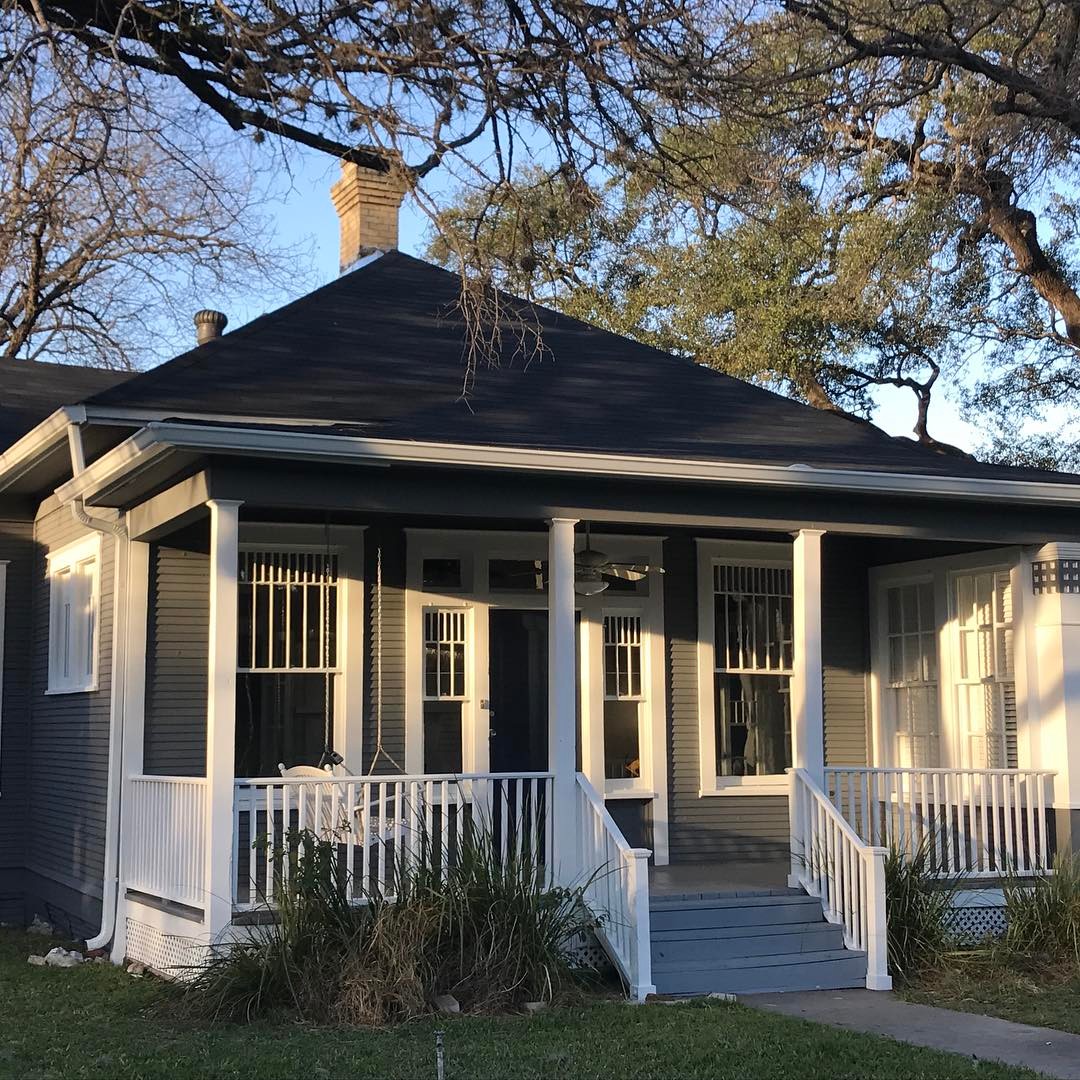 Front view of single-family home painted gray with white trim. Photo by Instagram user @east_magnolia_cottage