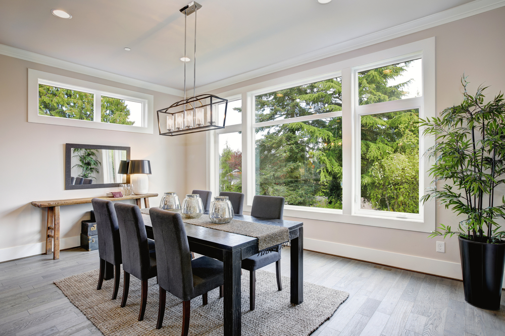 Open concept dining room with big windows and beige walls