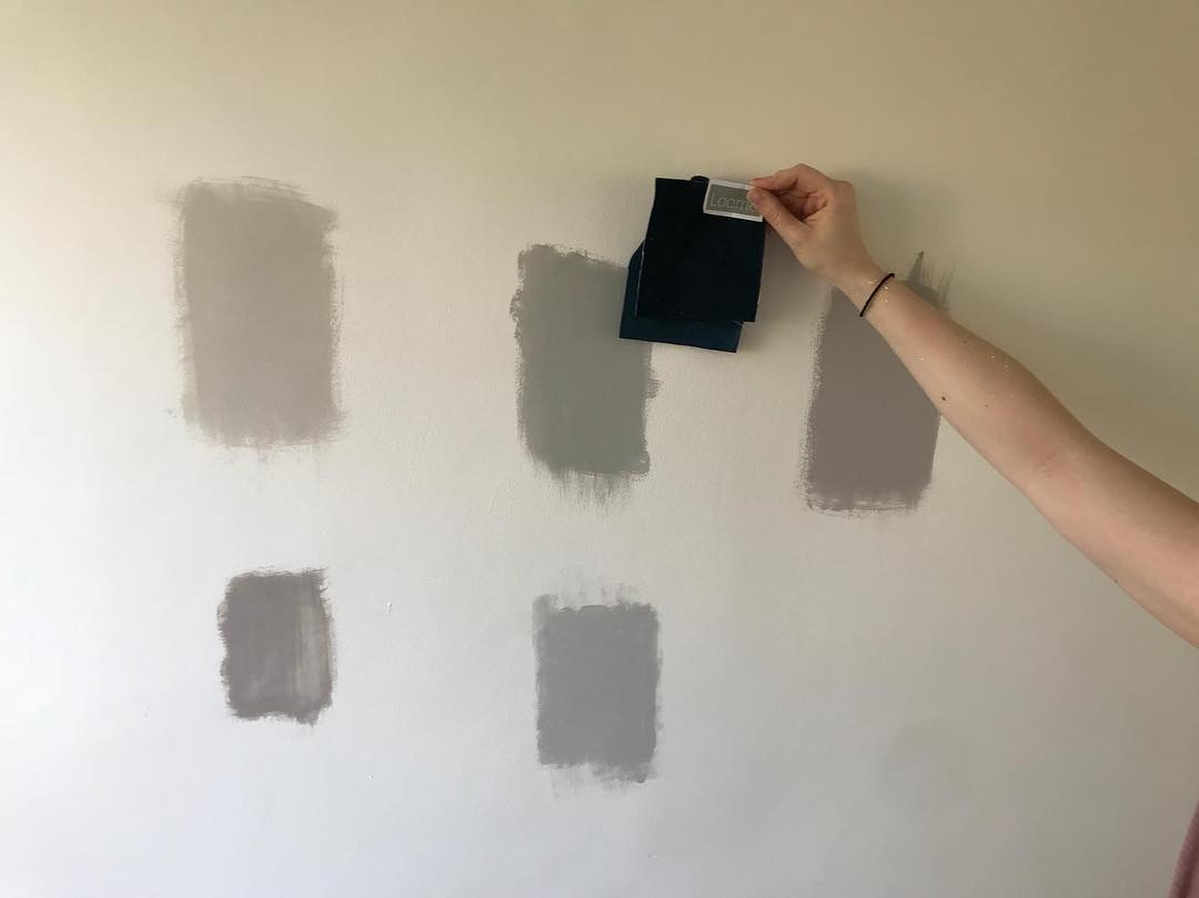 White wall with gray paint color patches. Photo by Instagram user @hospitalityandhome