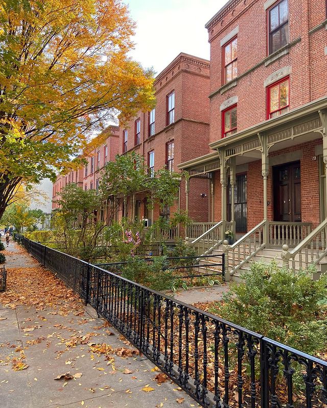 Exterior view of New York City brownstones in the fall. Photo by Instagram user @thecuriousuptowner