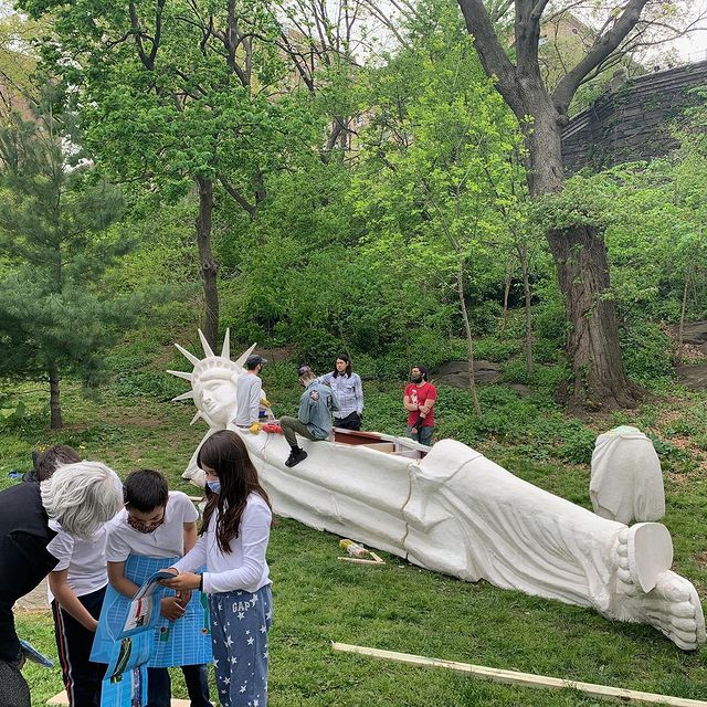 Young adults installing reclining liberty statue in Morningside Park. Photo by Instagram user @connieleecurated