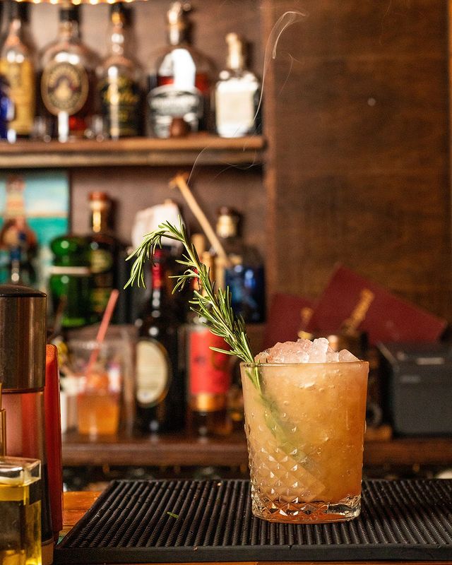 Cocktail with a green sprig at The Honey Well in New York City. Photo by Instagram user @thehoneywellnyc