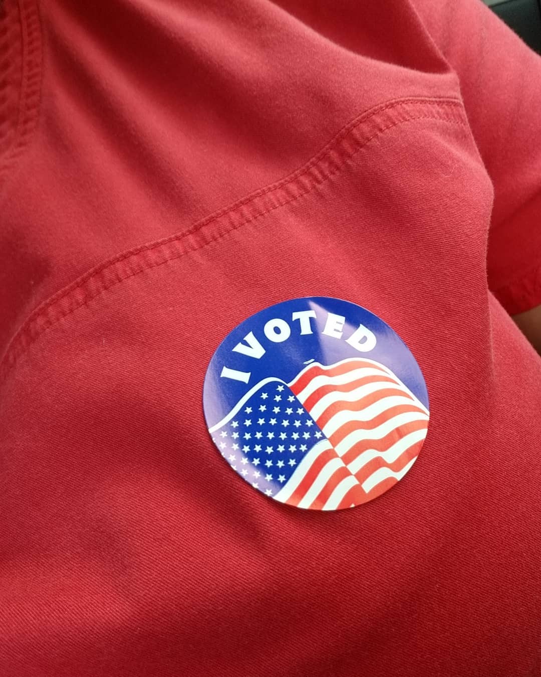 Woman wearing red t-shirt with I Voted sticker. Photo by Instagram user @lknjones