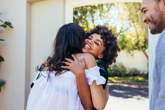 Two women hugging in doorframe