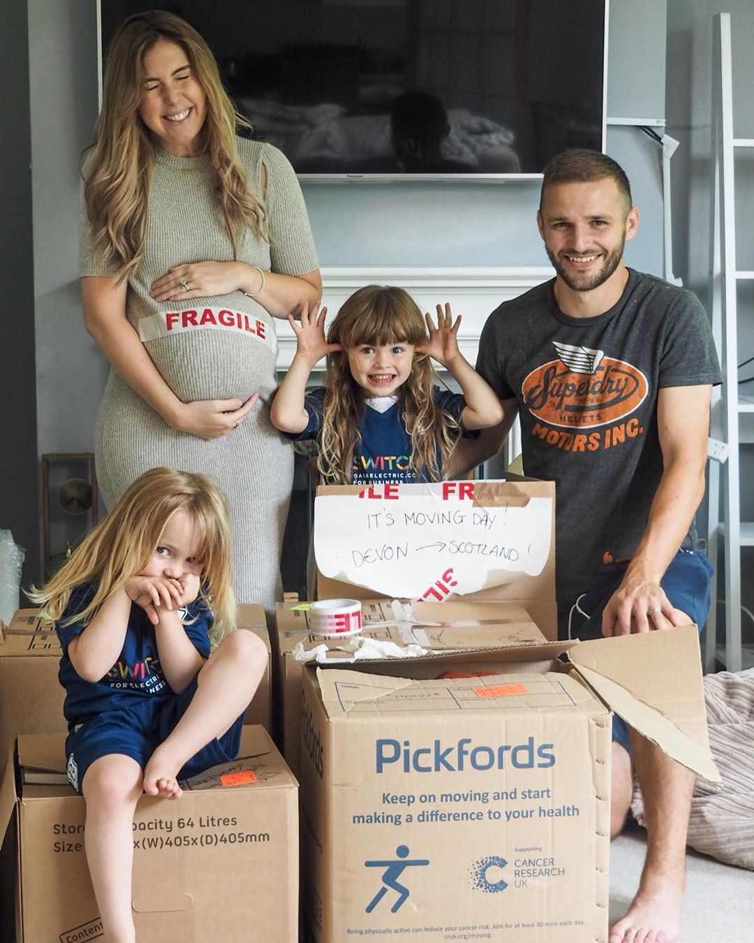 Family sitting around house with moving boxes. Photo by Instagram user @theimperfectlyperfectparent