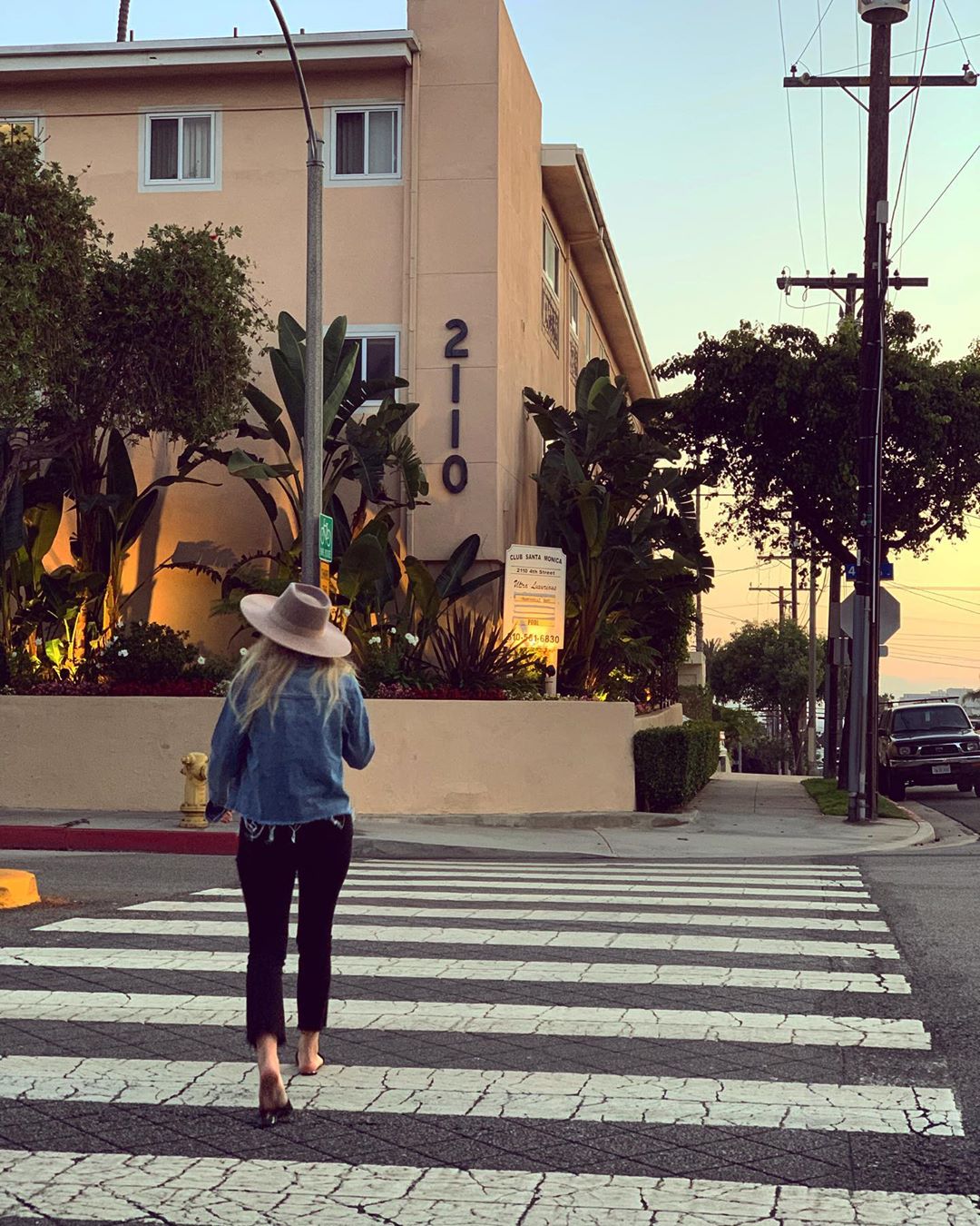 Woman strolling across street along Santa Monica Pier. Photo by Instagram user @birdeeclothing