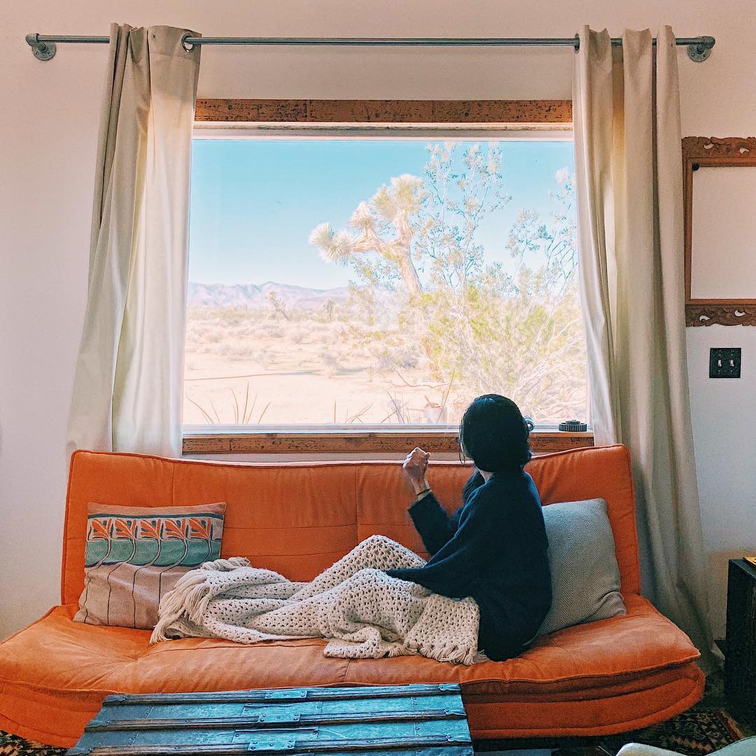 Women on Couch Staring Out Window. Photo by Instagram user @weiyeee