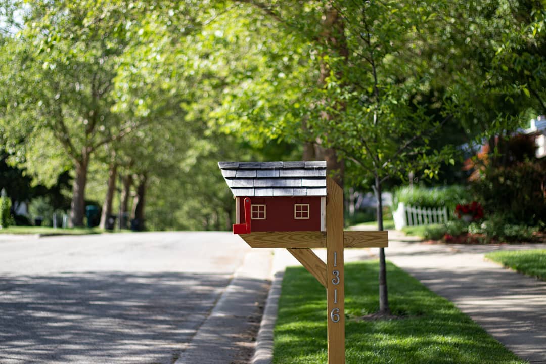 Red mailbox on street in neighborhood. Photo by Instagram user @naturallycurious93