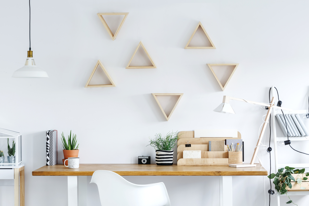 A decorated desk in a white room with wooden accents