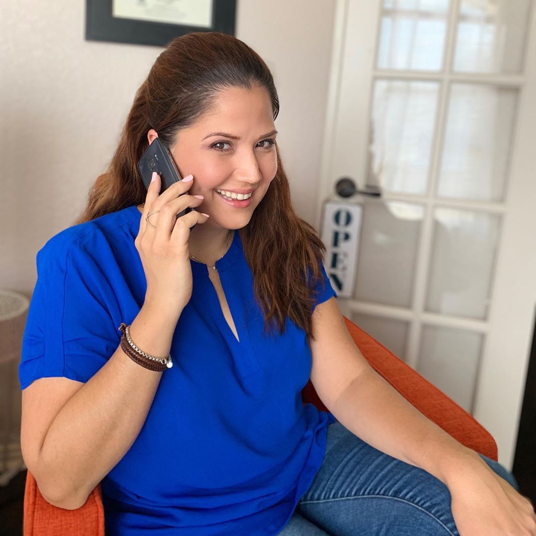 Woman in blue shirt talking on phone. Photo by Instagram user @blackstonestudio