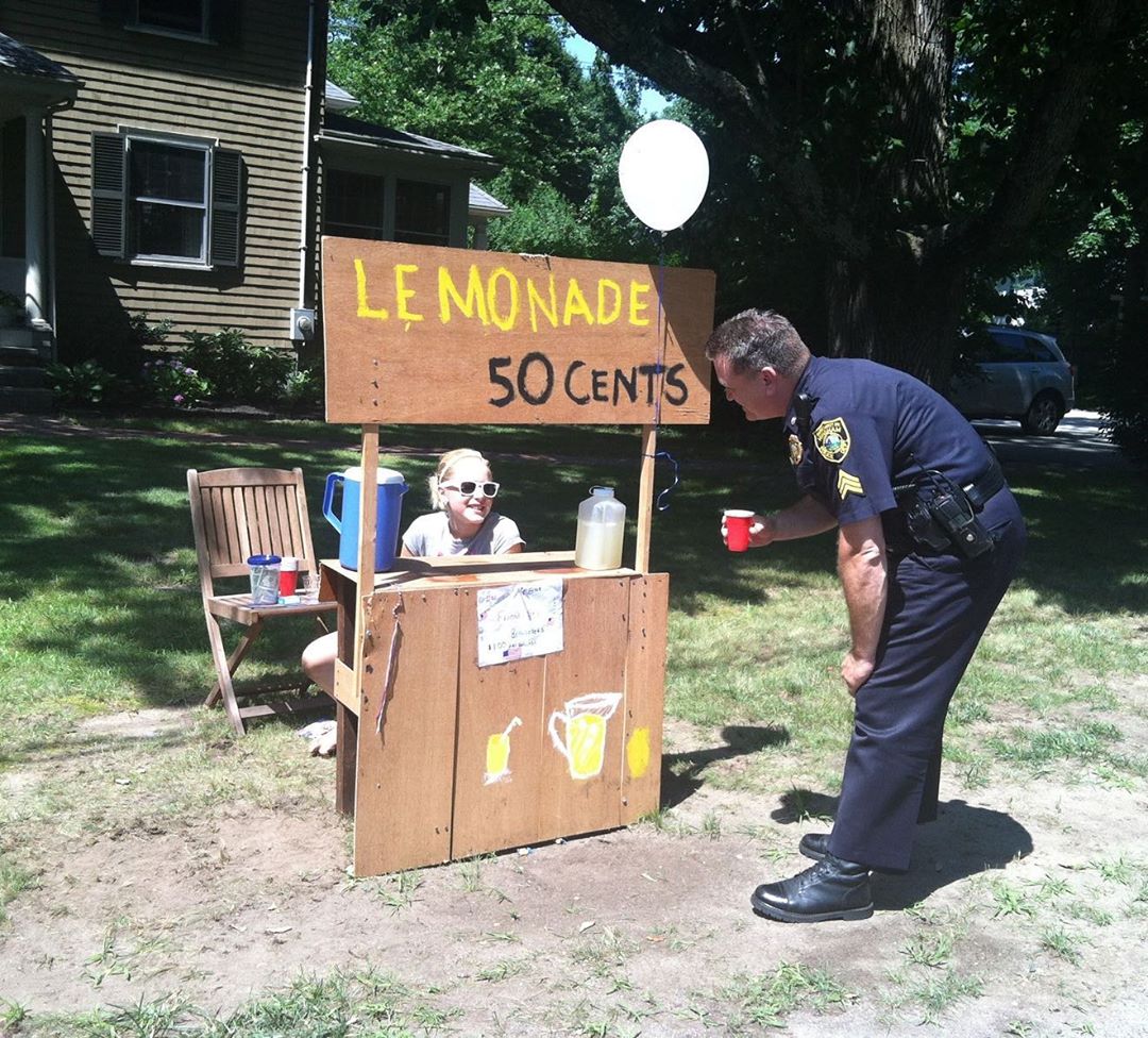 Policeman buying lemonade from lemonade stand. Photo by Instagram user @sgtstevendearth