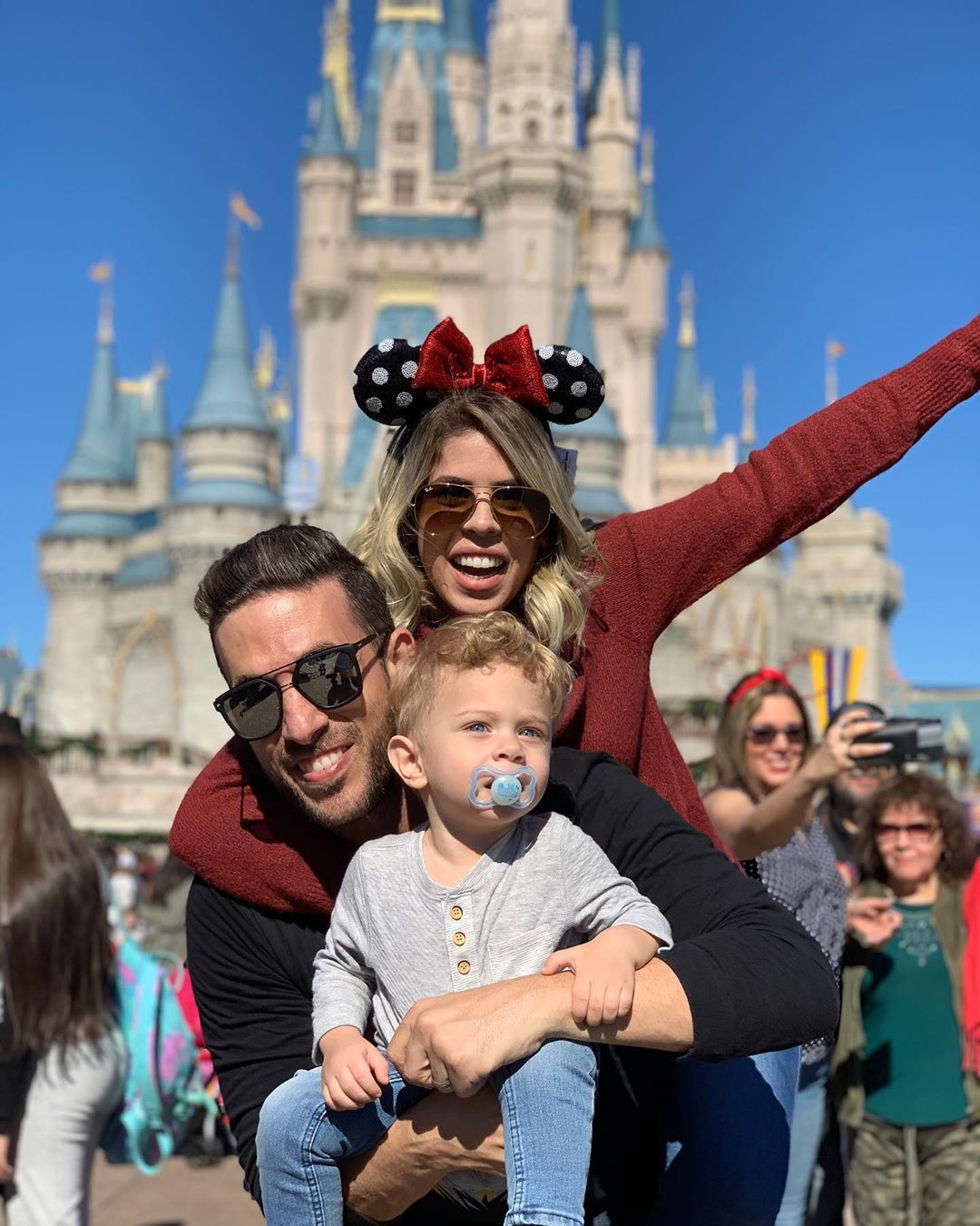 Family posing in front of castle at Disney World. Photo by Instagram user @sallyderogatis