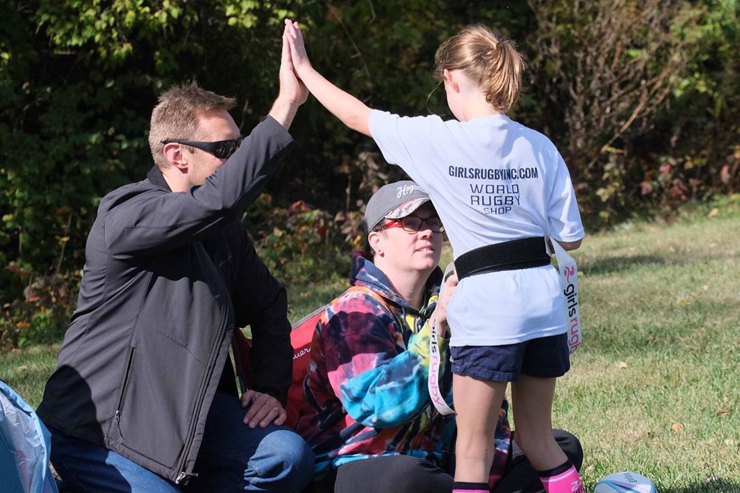 Dad and daughter high fiving. Photo by Instagram user @girlsrugbywa