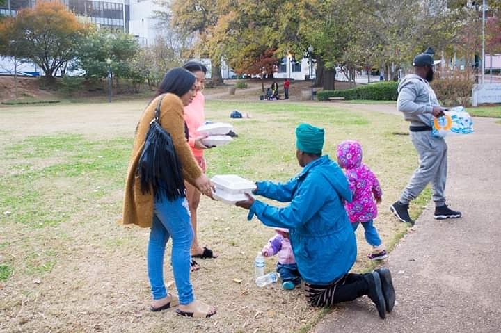 Woman giving homeless person food. Photo by Instagram user @ridockking