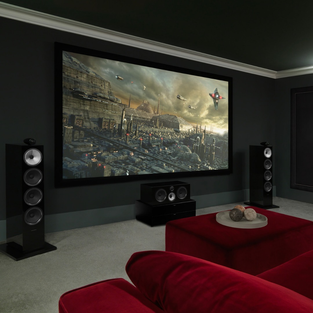 Dark Theater Room with Red Couch and Large Speakers. Instagram Photo by @bowerswilkins