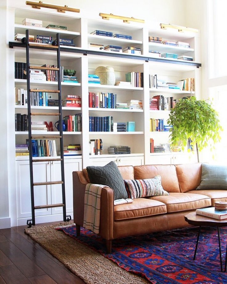 home library with small ladder installed to get to higher shelves photo by Instagram user @jennykomenda