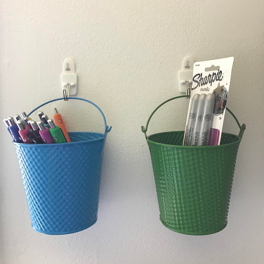 Buckets hanging on hooks with craft supplies. Photo by Instagram user @psiloveyou_crafts