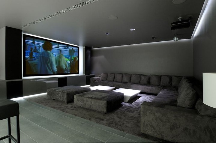 large sectional seating with projector screen with soft white lighting photo by Instagram user @audiocommandfl