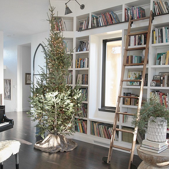 rustic style home library with wooden ladder and christmas tree photo by Instagram user @jenniferrizzodesigncompany