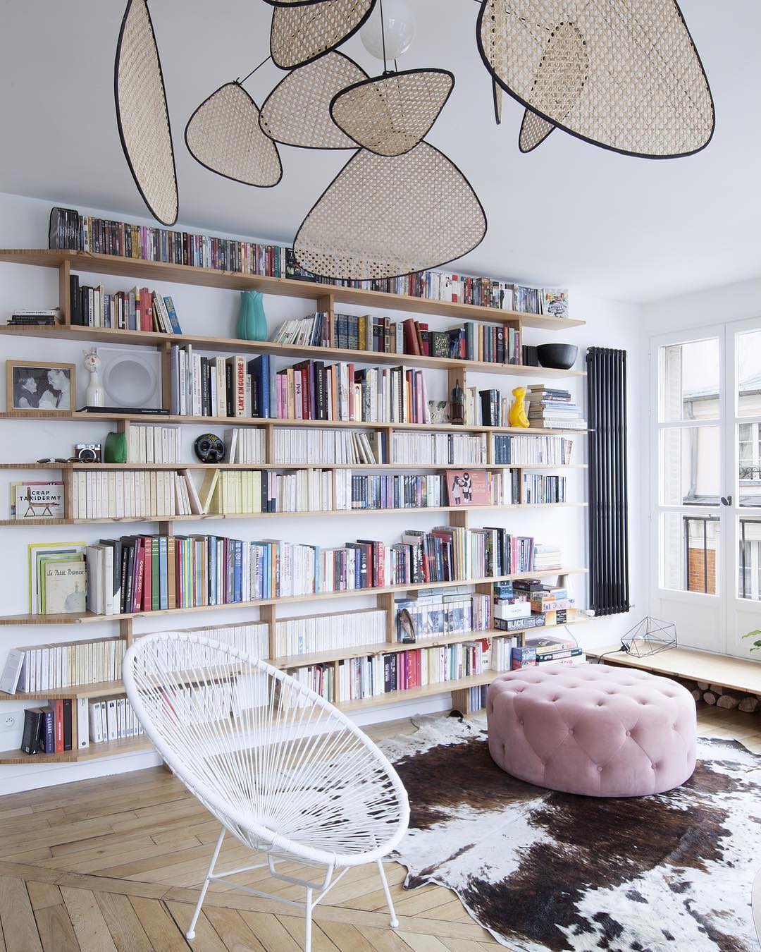 modern home library with floating shelves and comfortable seating photo by Instagram user @madedotcom