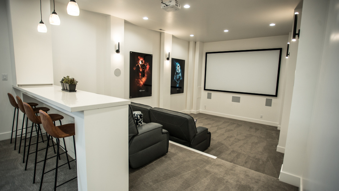 White theater room with a bar and movie posters. Photo by Instagram user @mod.scapes