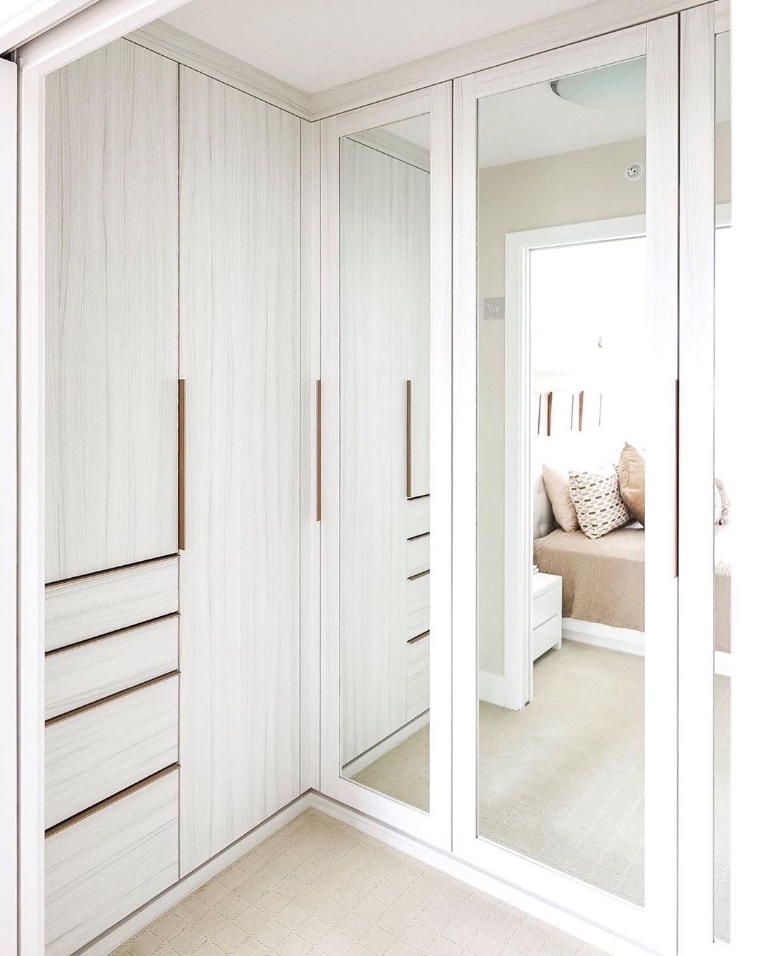 Walk-in closet with floor to ceiling mirrors. Photo by Instagram user @steph.pollard.design