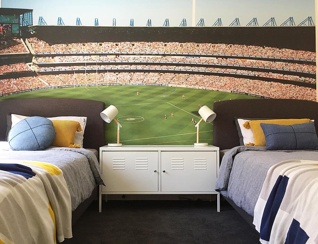 Boys shared bedroom design with soccer themed wall art.