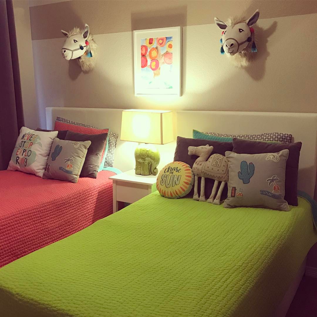 Shared kids bedroom with pink and green twin beds.