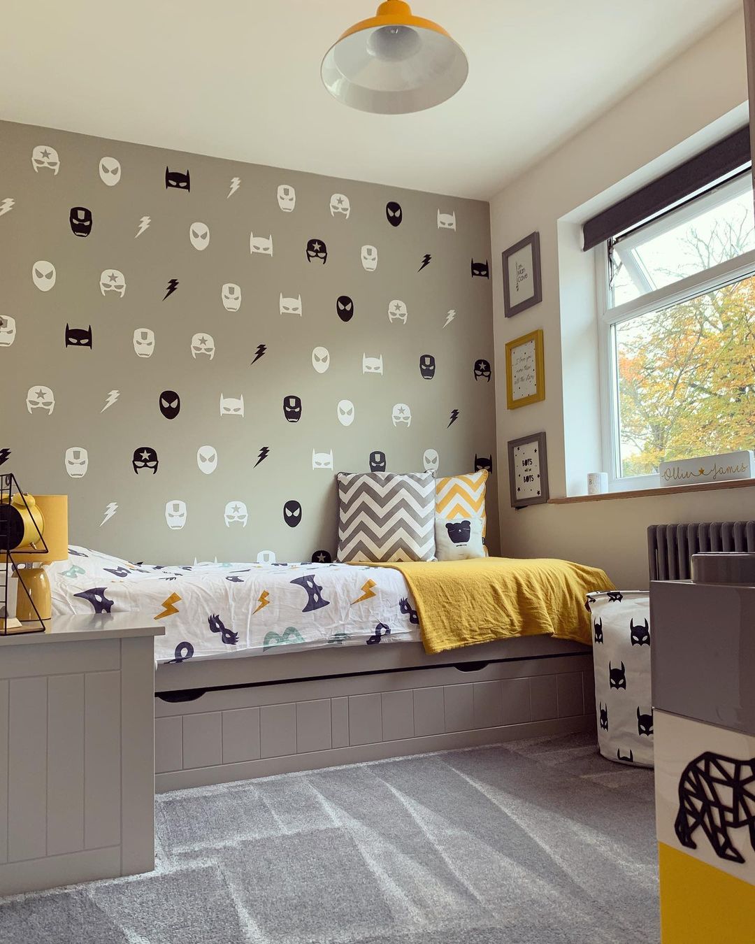 Boys bedroom with superhero wallpaper and decor.