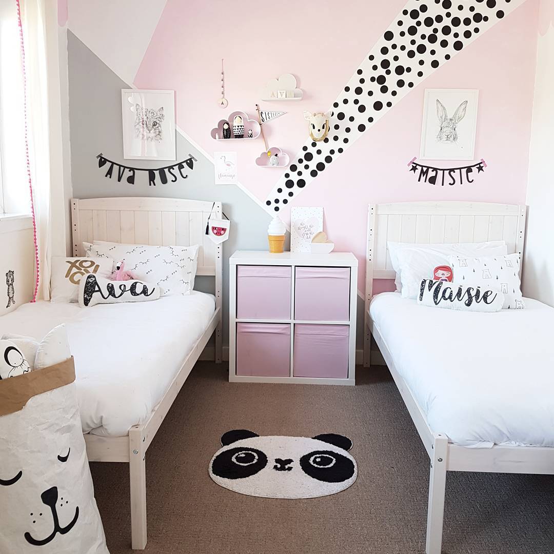 Girls bedroom design featuring names on pillows and wall decor.