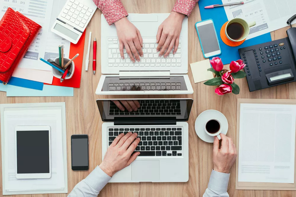 Two people working at the same desk