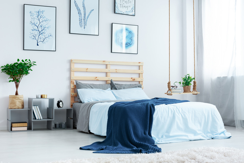 A decorated bedroom with a gray, blue, and white color palette