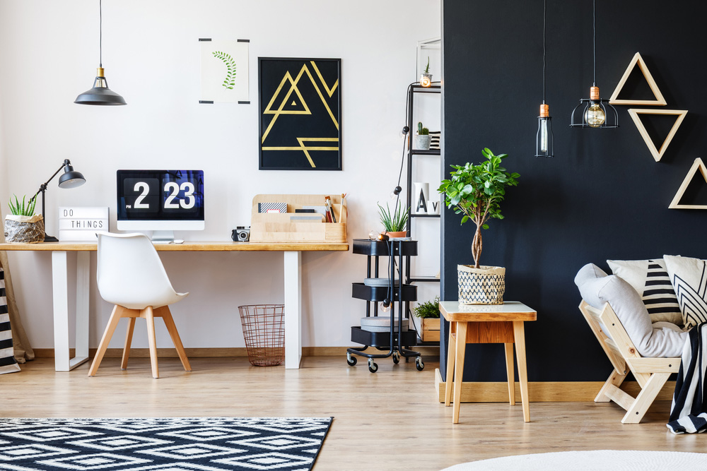 A room with a desk and seating area with black gold and white decorations