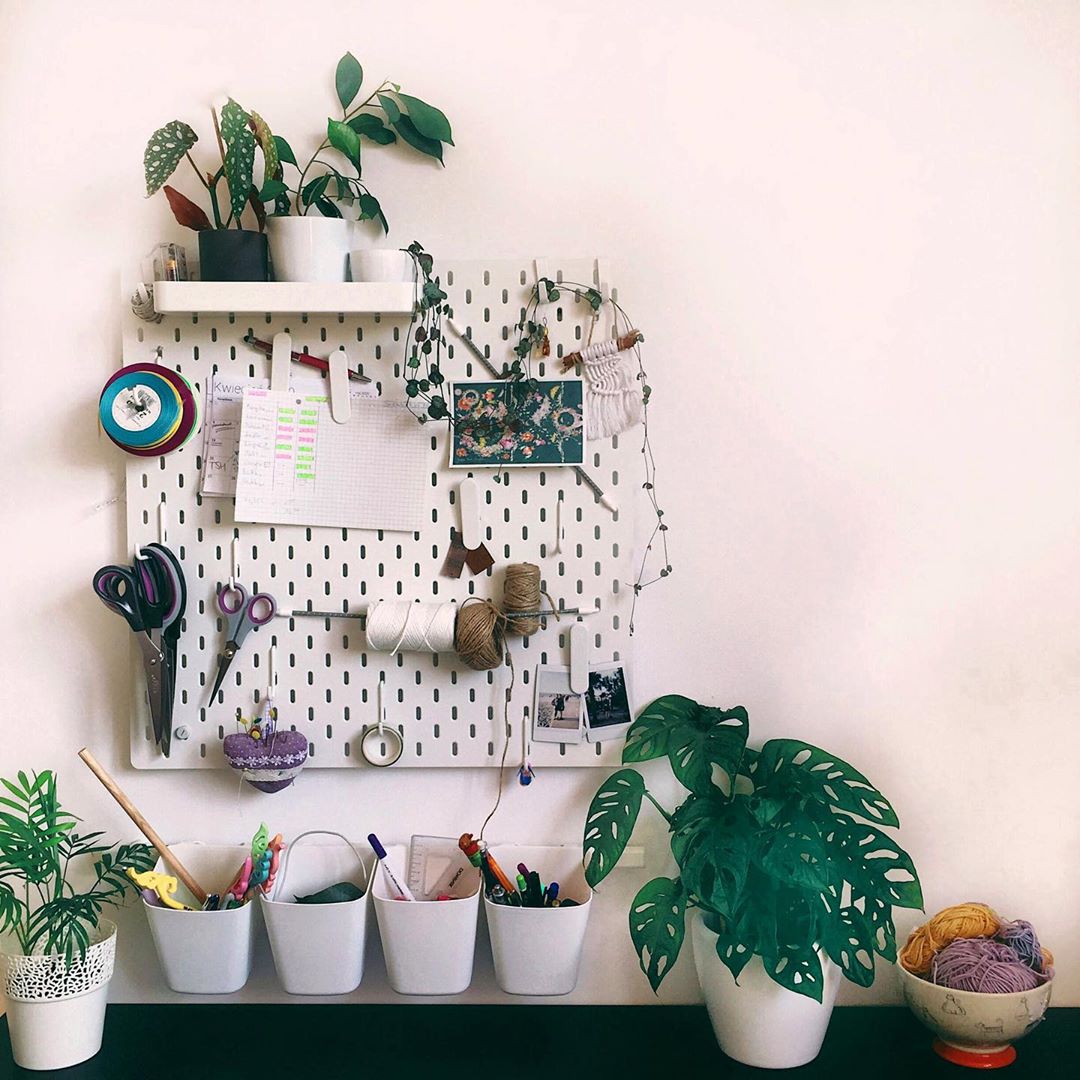 Wall-mounted pegboard and storage cups in craft room. Photo by Instagram user @byquanna