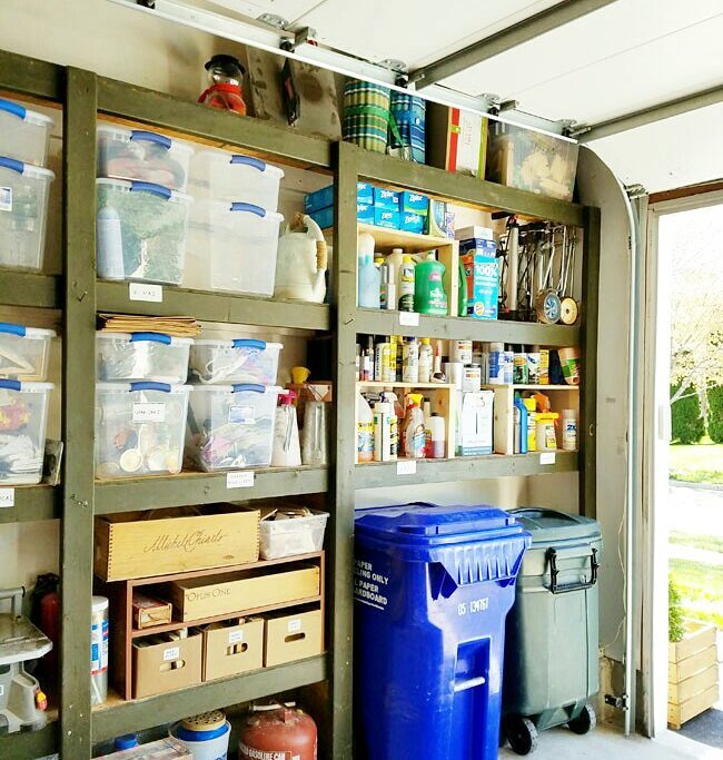 Garage items neatly organized onto shelves with a trash and a recycling bin. @remodelacasa..