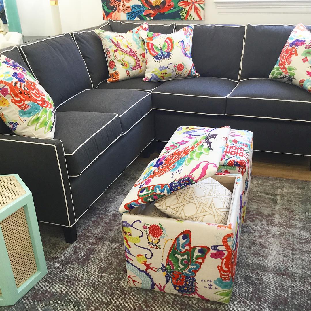 Colorful storage ottomans in place of a coffee table. Photo by Instagram user @shopdecorenvy