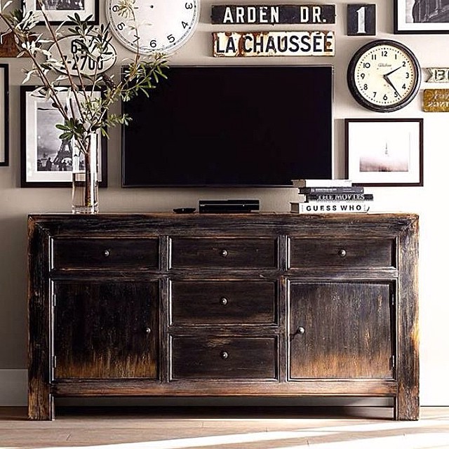 Distressed wood dresser used as TV stand in rustic style living room. Photo by Instagram user @dariageiler