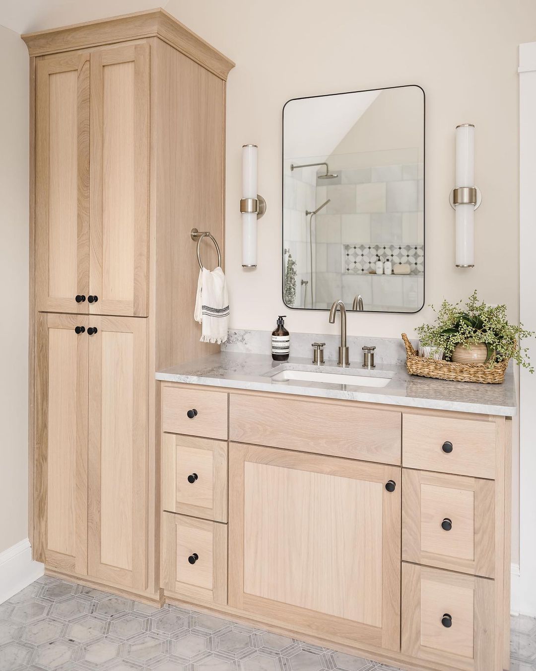 Light wood freestanding cabinets in a bathroom. Photo by Instagram user @delphiniumdesign.