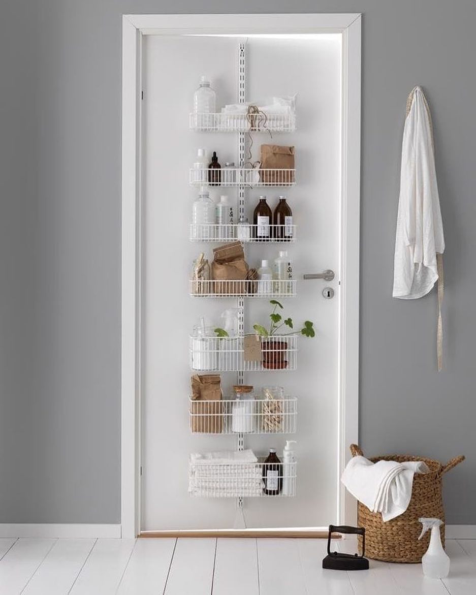 Bathroom Door with Hanging Rack Storing Cleaning Supplies. Photo by Instagram user @glasshouseintl