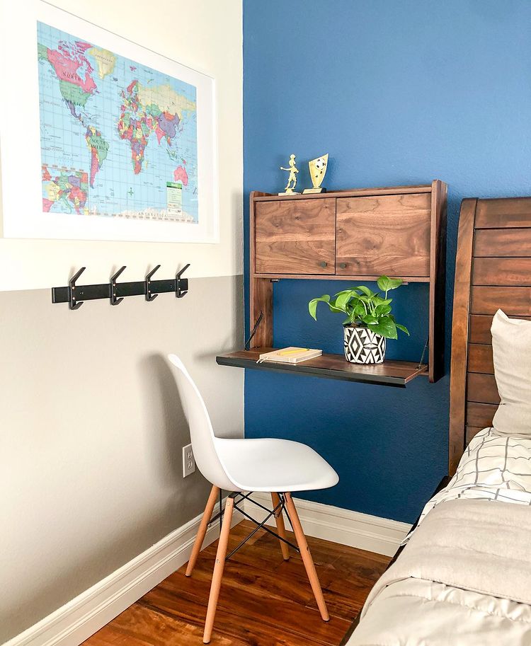 Dark-washed wood fold-down desk with white desk chair. Photo by Instagram user @k_home_and_designs