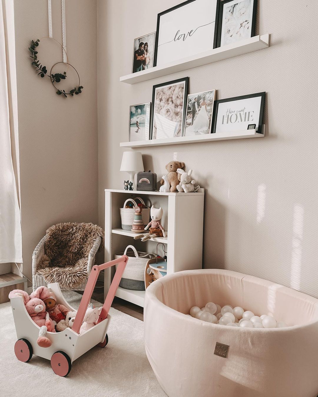 Soft pink ball pit with a matching wagon, book case, and gallery wall. Photo by Instagram user @jacky.by.life.