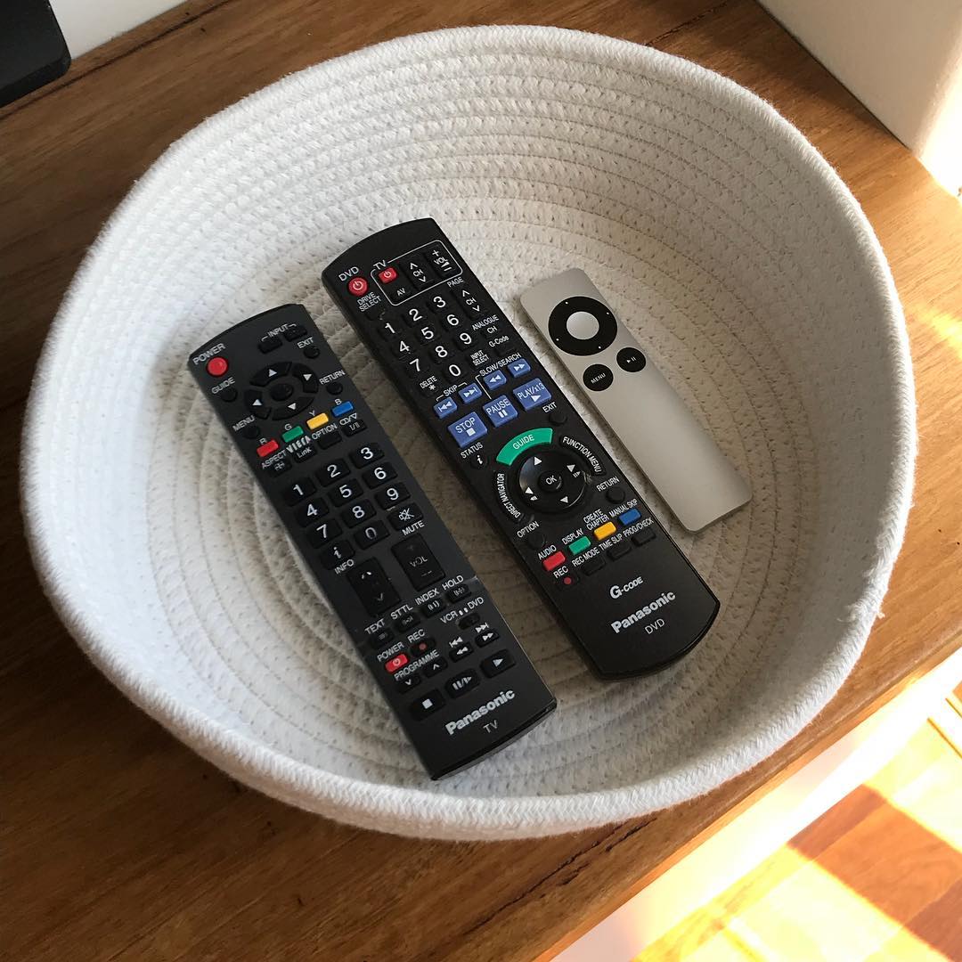 Three remotes in a white weaved basket. Photo by Instagram user @willowandwood.