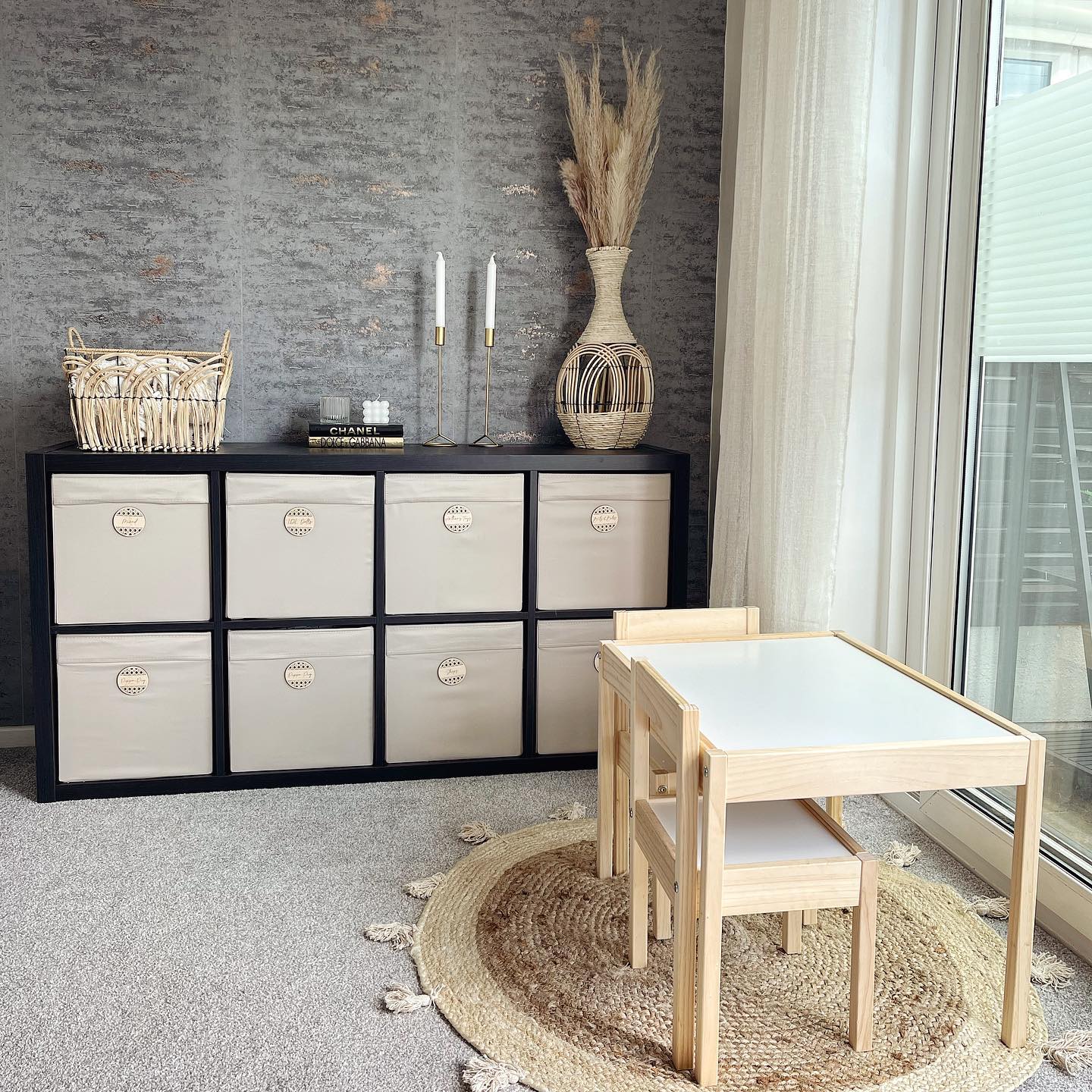 Small light wood table set with dark wood storage set and neutral storage bins. Photo by Instagram user @hannahs.home.styling.