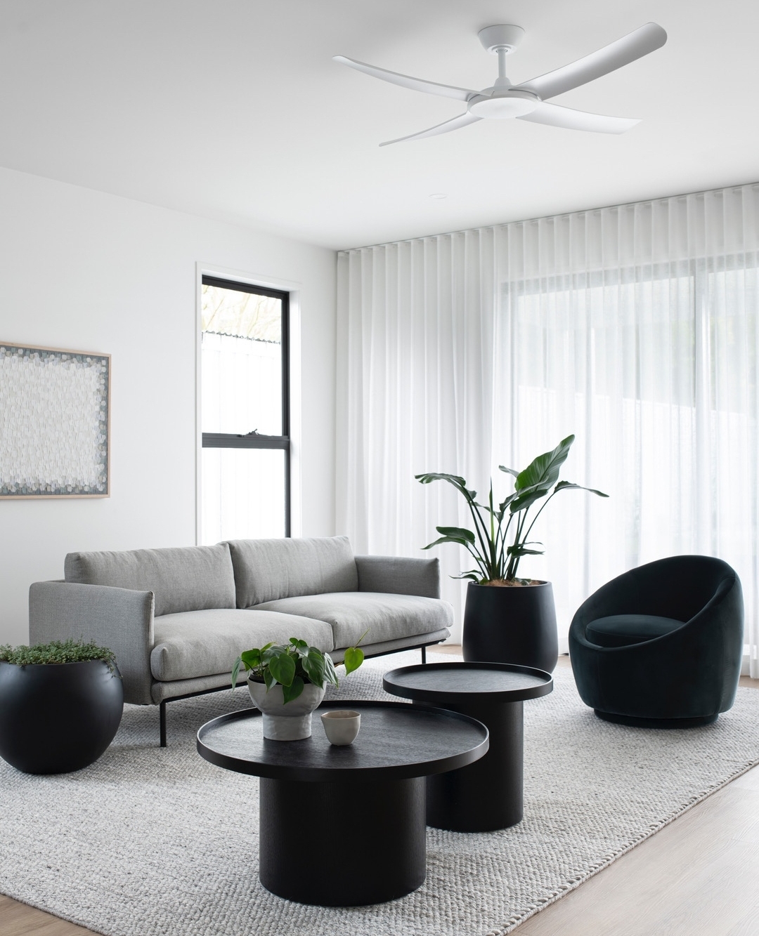 Grey-scale minimalist living room with natural light. Photo by Instagram user @zephyr_and_stone.