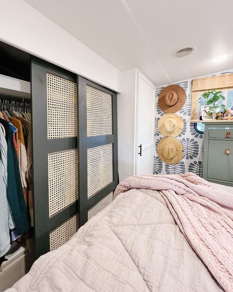 RV bedroom with printed wallpaper and sliding closet doors. photo credit @atwellathome