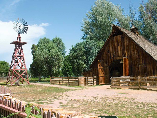 A look at a farmhouse, with a rustic windmill and barn. @belocallittleton